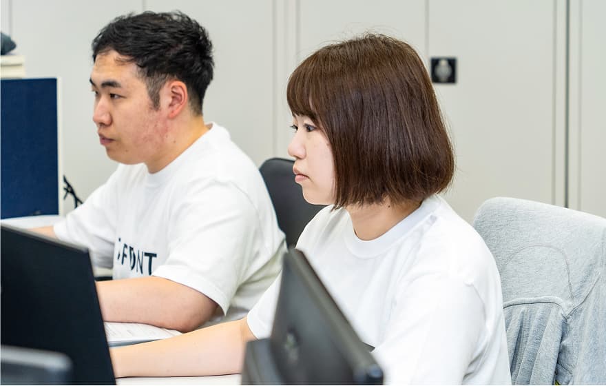 パソコンに向かって並んで作業している2人のスタッフの写真
