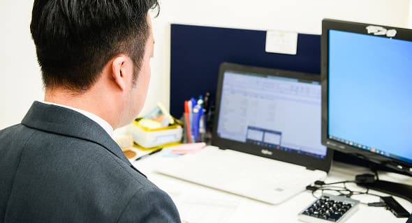 パソコンで資料を確認している男性の写真