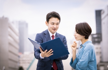 男性と女性が書類を見ている写真