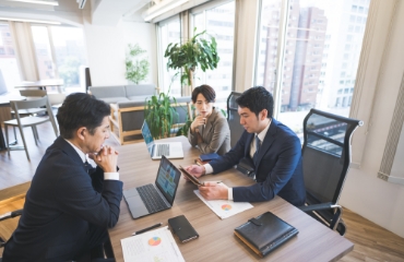 男性3人が会議をしている写真