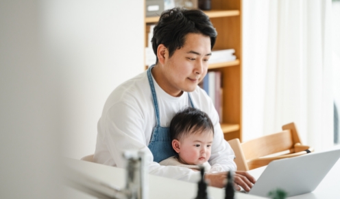 男性の膝の上に座っている赤ちゃんの写真